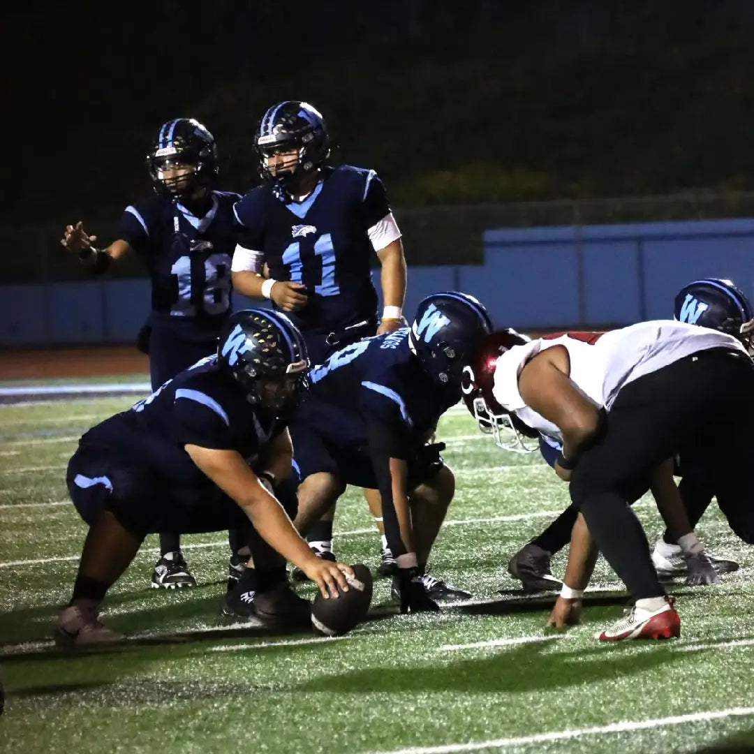 Football players in action on a field at night